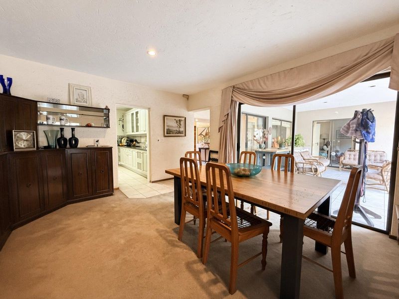 Dining room featuring built-in cabinetry, carpeted flooring, and large sliding glass doors providing access to the covered patio area.