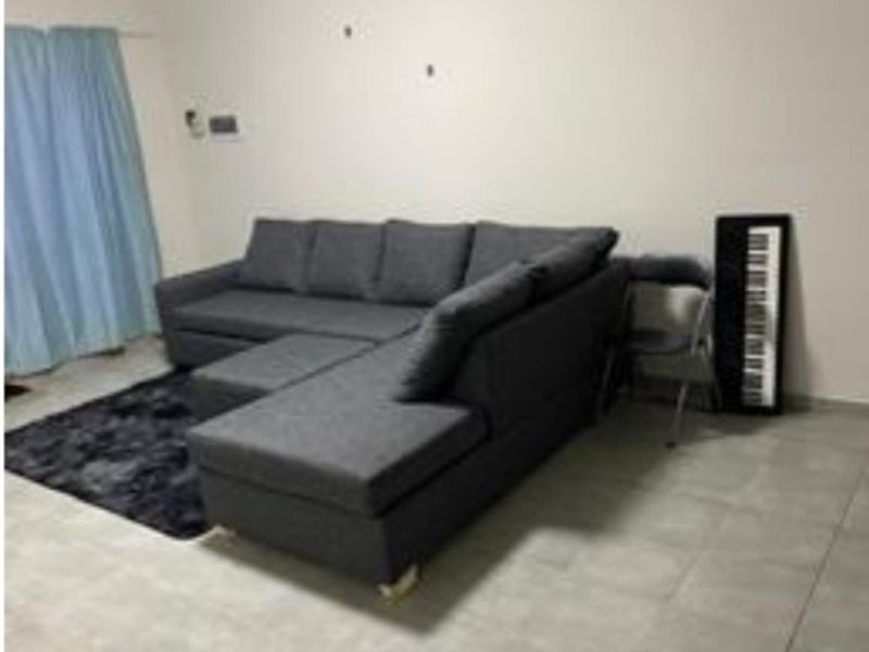 A living room area featuring tiled flooring and neutral wall finishes, providing a functional space for relaxation.
