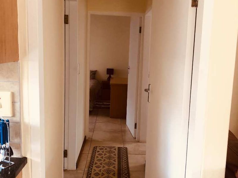 A functional hallway connecting interior rooms, featuring tiled flooring and standard door frames.