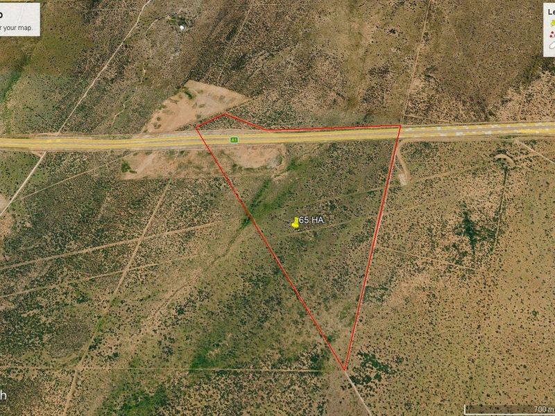 Aerial view of a 65-hectare agricultural land parcel with direct highway frontage.