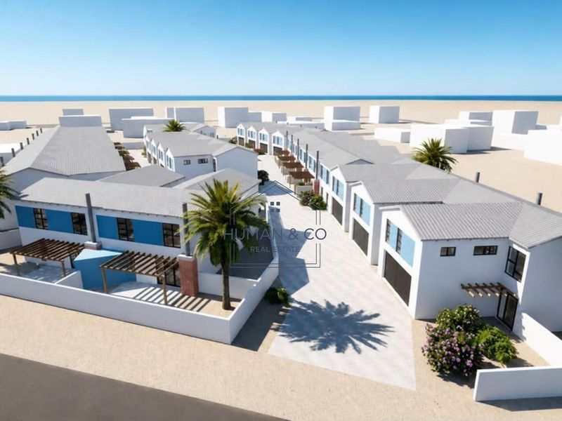 Aerial view of a modern townhouse development featuring uniform pitched roofs, paved driveways, and private outdoor pergola areas.