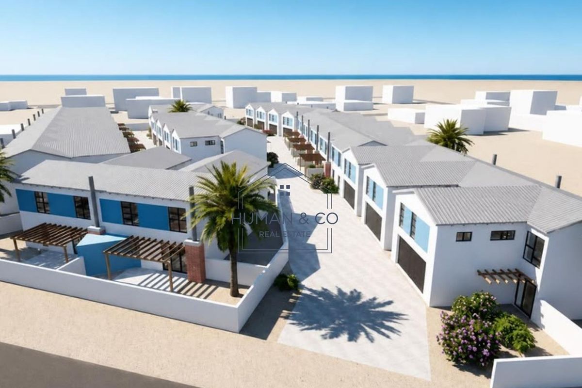 Aerial view of a modern townhouse development featuring uniform pitched roofs, paved driveways, and private outdoor pergola areas.
