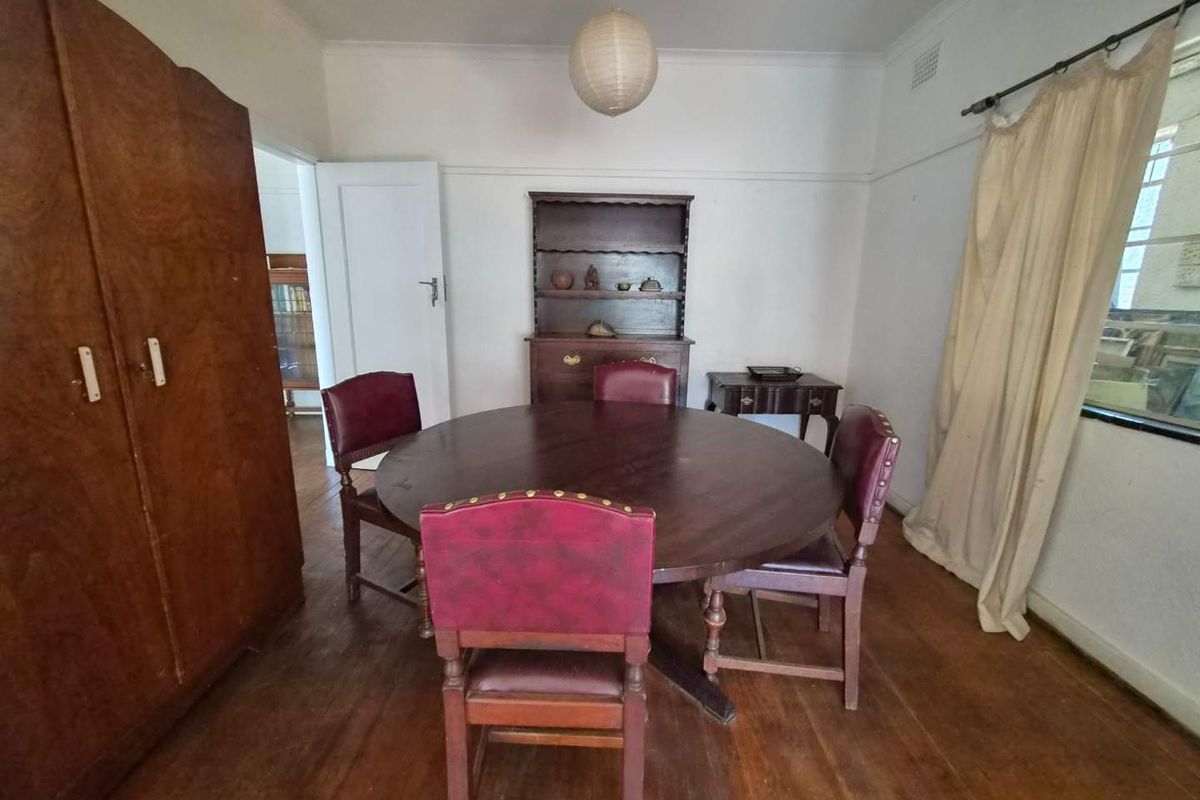 A traditional dining room featuring original hardwood flooring, picture rails, and coved ceilings, offering a classic foundation for renovation or modern restyling.