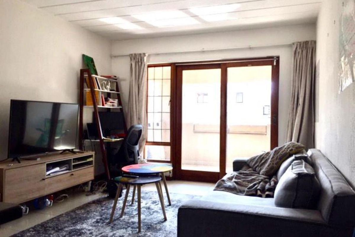 A living room featuring tiled flooring and a sliding glass door that provides access to an outdoor area.