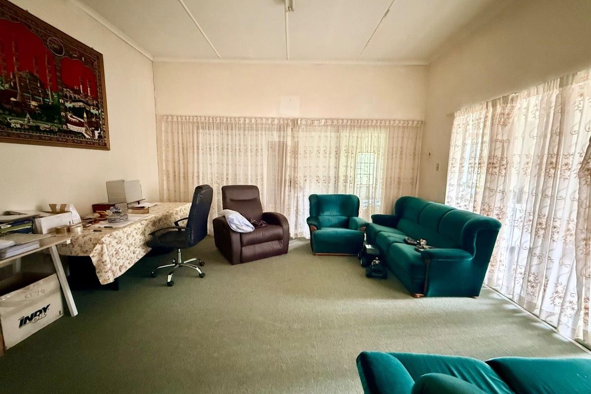 Spacious living room featuring wall-to-wall carpeting, large sliding glass doors with curtains, and neutral wall finishes.
