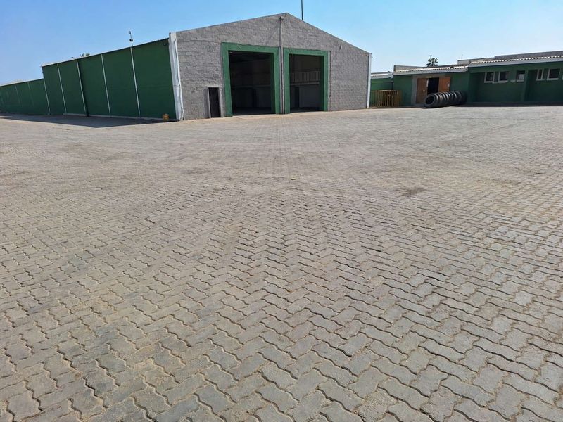 Spacious industrial property featuring a large paved yard and warehouse facility with high-clearance access points.