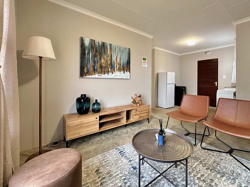 Open plan living area featuring polished concrete floors, neutral wall tones, and a coved ceiling, providing a versatile and modern living space.