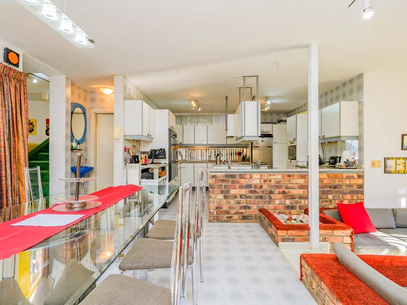 Open plan living and kitchen area featuring a brick breakfast bar, built-in cabinetry, and tiled flooring throughout.