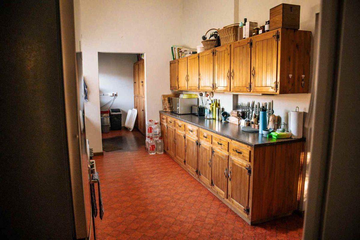 A functional kitchen featuring traditional wooden cabinetry, ample storage space, and durable vinyl flooring, offering potential for a modern renovation.