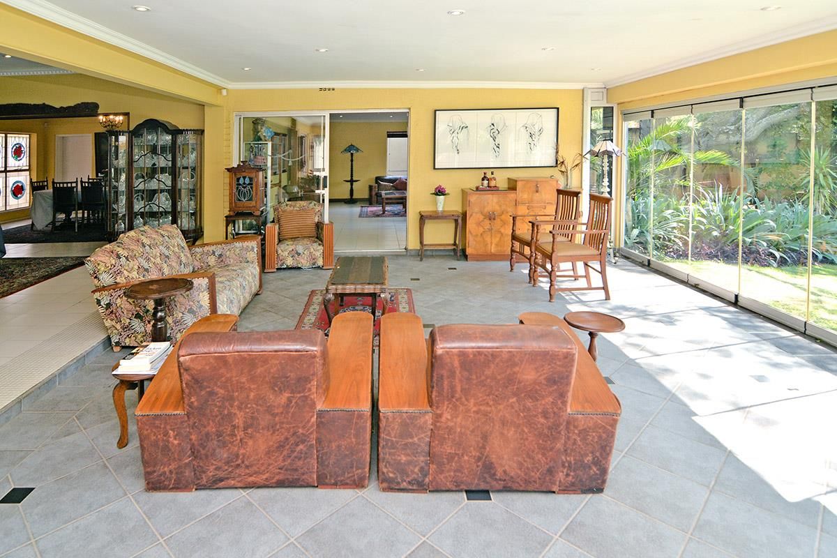 Spacious sunroom featuring large glass sliding doors, tiled flooring, and recessed lighting, offering a seamless transition to the garden area.