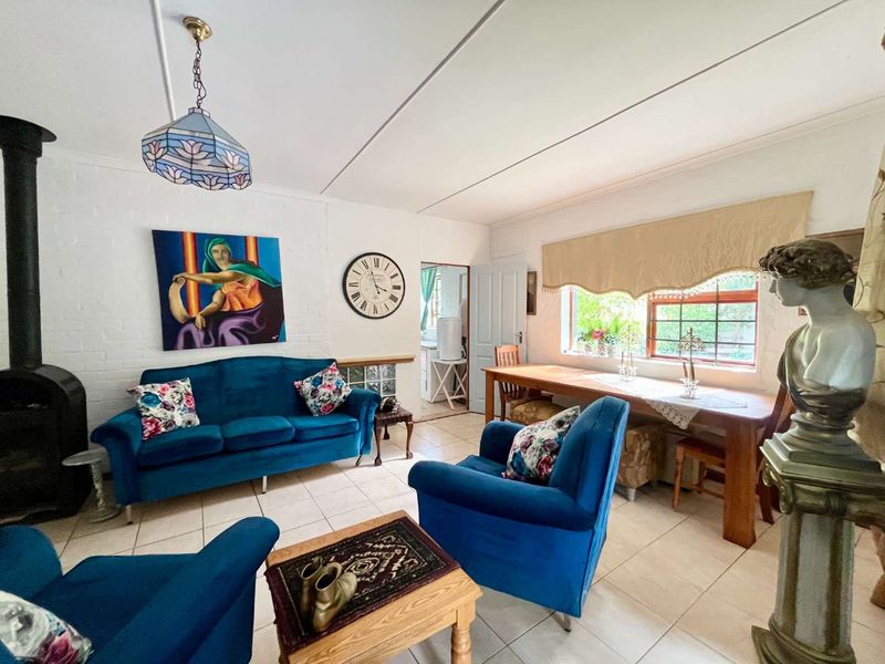 A cozy living room featuring a wood-burning fireplace, tiled flooring, and a window with security bars, offering a comfortable and functional living space.