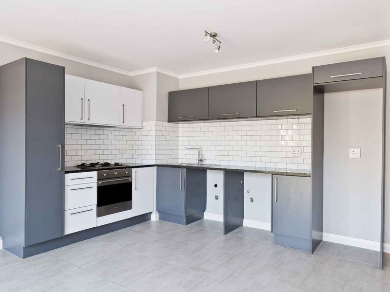 Modern kitchen featuring two-tone cabinetry, subway tile backsplash, built-in oven, gas hob, and dedicated spaces for under-counter appliances.