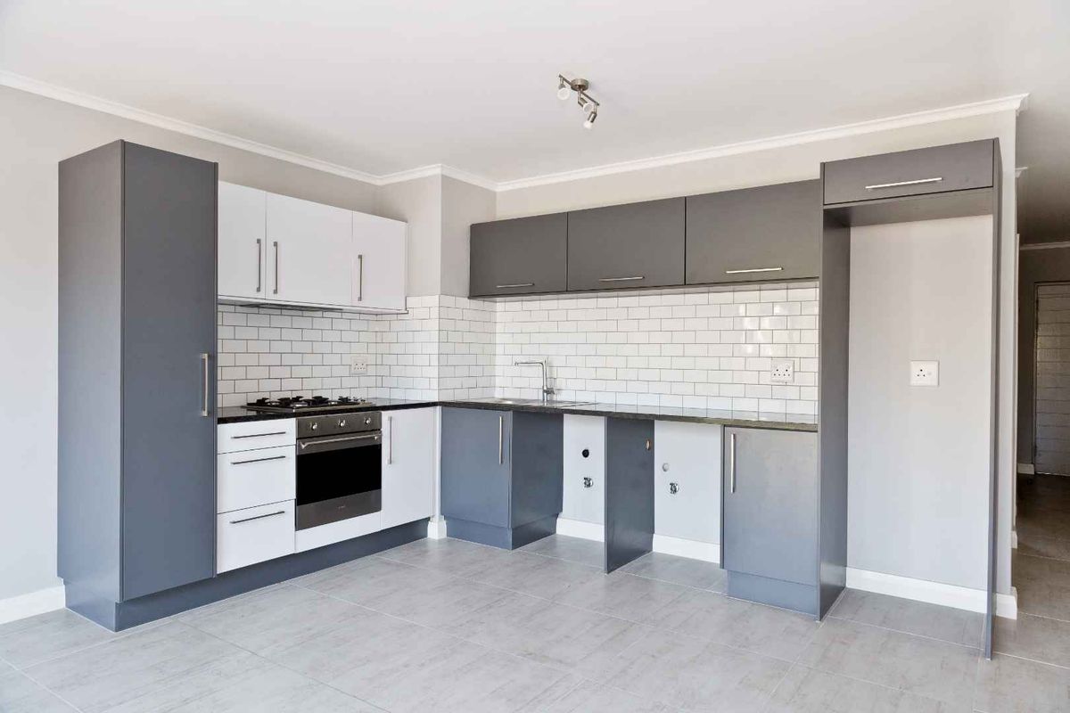 Modern kitchen featuring two-tone cabinetry, subway tile backsplash, built-in oven, gas hob, and dedicated spaces for under-counter appliances.