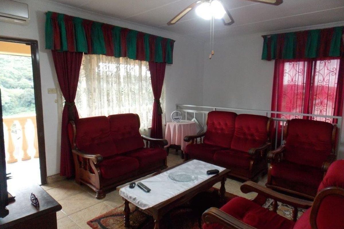 A living room featuring tiled flooring, a ceiling fan, and a split system air conditioner, with access to an adjacent balcony.