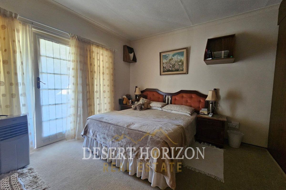 A bedroom featuring carpeted flooring and a glass sliding door providing access to the exterior.