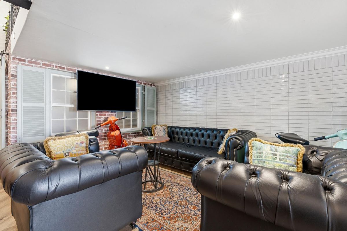 A well-lit living area featuring a combination of exposed brickwork and modern subway tile wall finishes, creating a unique industrial-style aesthetic.