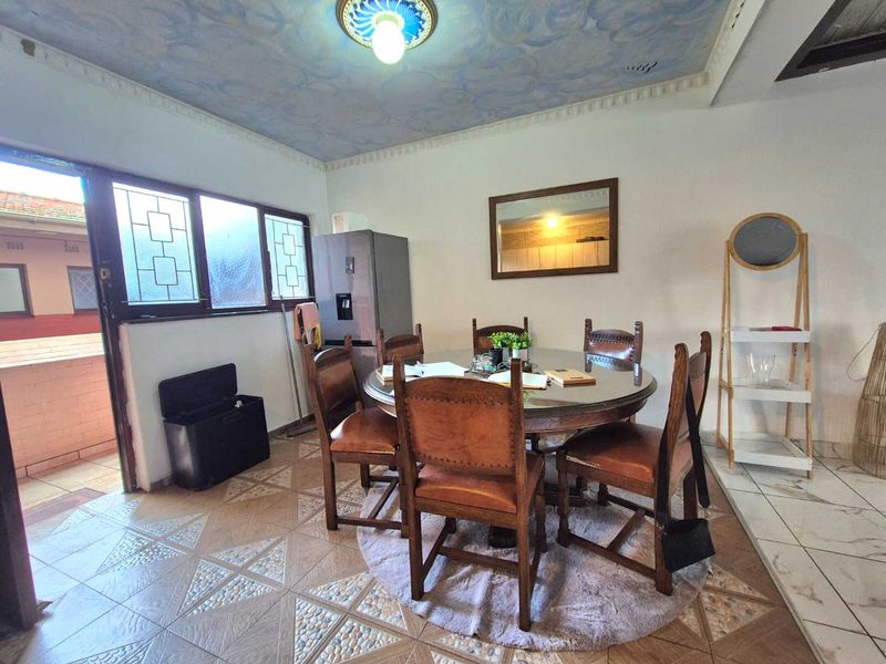 Dining area featuring decorative ceiling molding, tiled flooring, and direct access to an outdoor balcony through a sliding glass door.