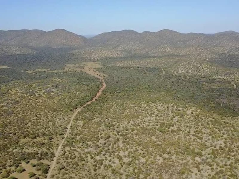 An expansive aerial view of the farm property featuring natural bushveld landscape and a winding dirt access road.