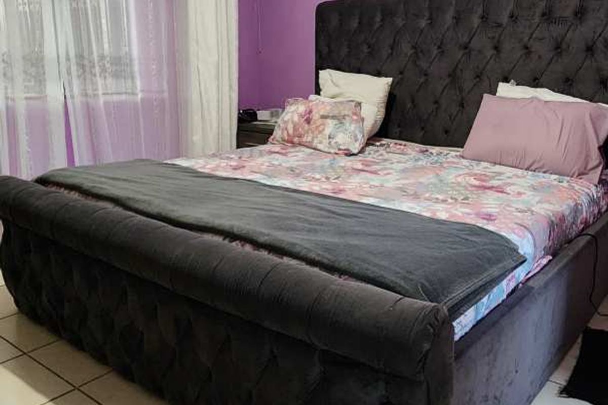 A bedroom featuring tiled flooring and purple painted walls, providing a functional space for rest.