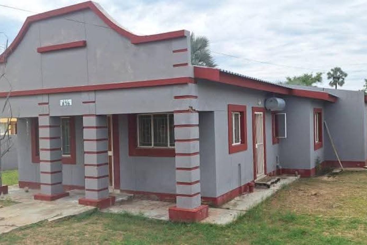 Front elevation of a single-story house featuring a covered porch with decorative pillars and a grey and red exterior color scheme.