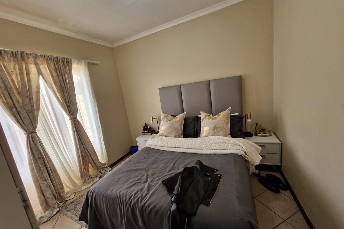 A bedroom featuring tiled flooring and a sliding door with curtains, providing access to an outdoor area.