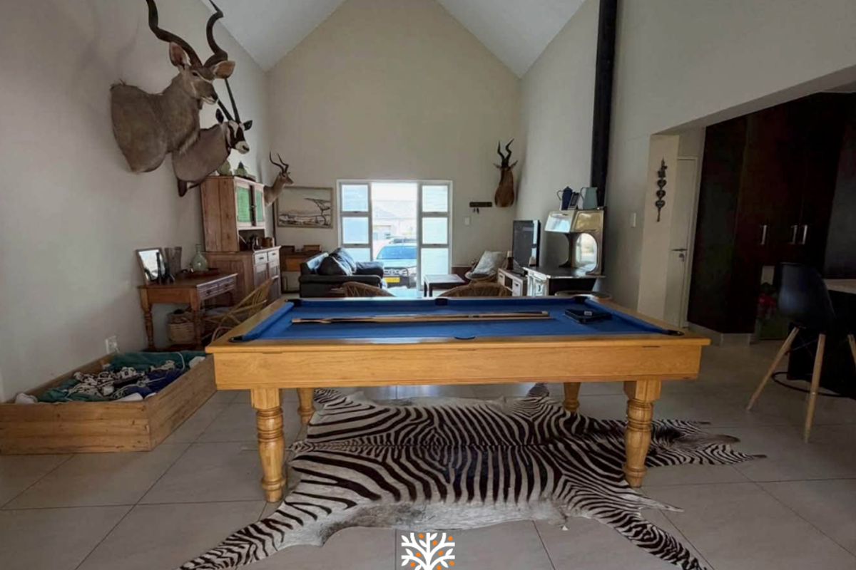 Spacious living area featuring a high vaulted ceiling, tiled flooring, and a prominent freestanding fireplace, offering a bright and open atmosphere.