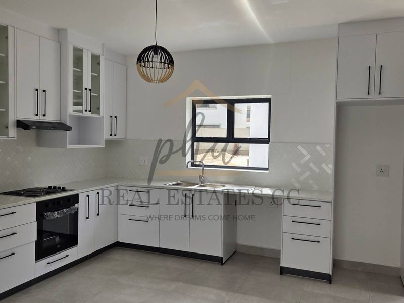 Modern kitchen featuring white cabinetry, stone countertops, built-in oven, gas hob, and a tiled backsplash in a clean, contemporary layout.