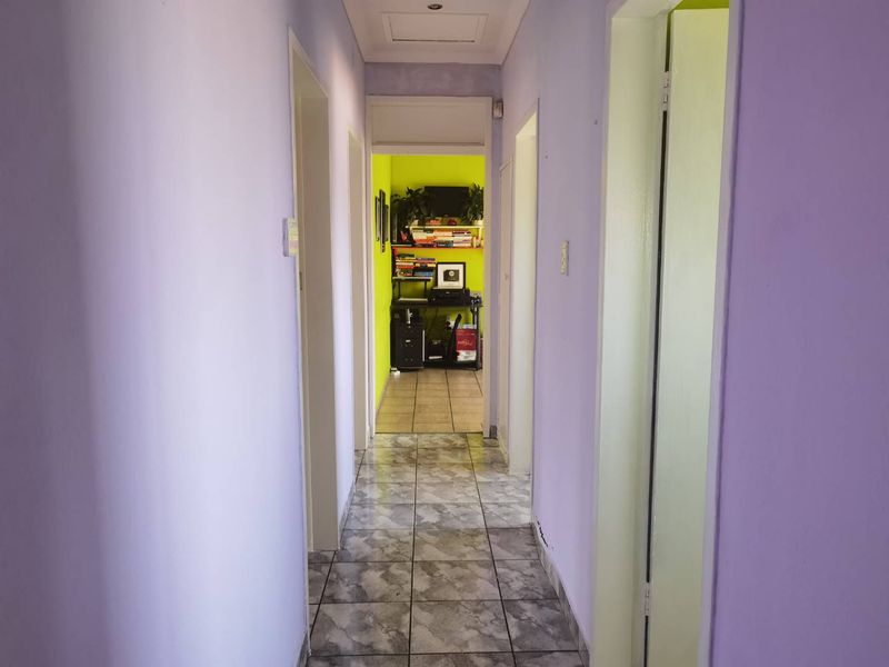 A functional hallway featuring tiled flooring and multiple doorways leading to adjacent rooms.