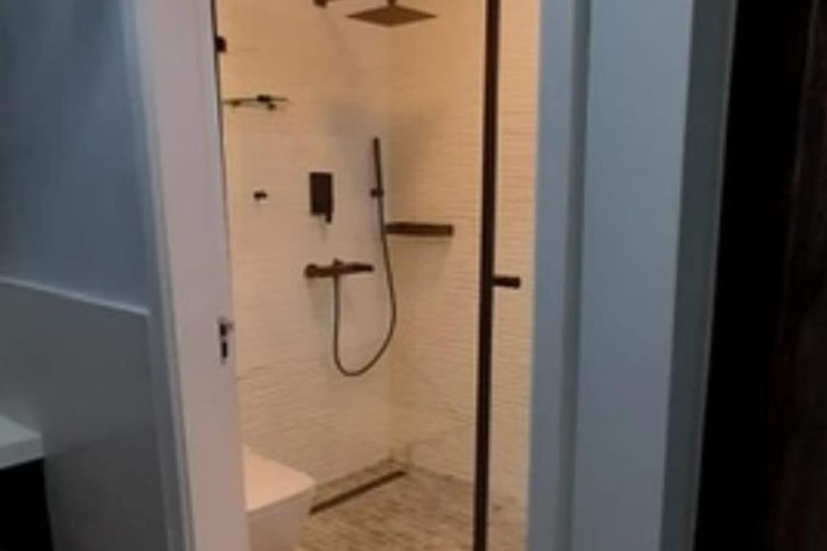 A modern, well-appointed bathroom featuring a walk-in shower with a glass screen, contemporary fixtures, and clean tiled finishes.