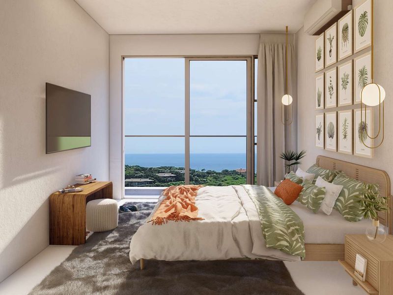 A modern bedroom featuring a large sliding glass door with scenic ocean views and a wall-mounted air conditioning unit.
