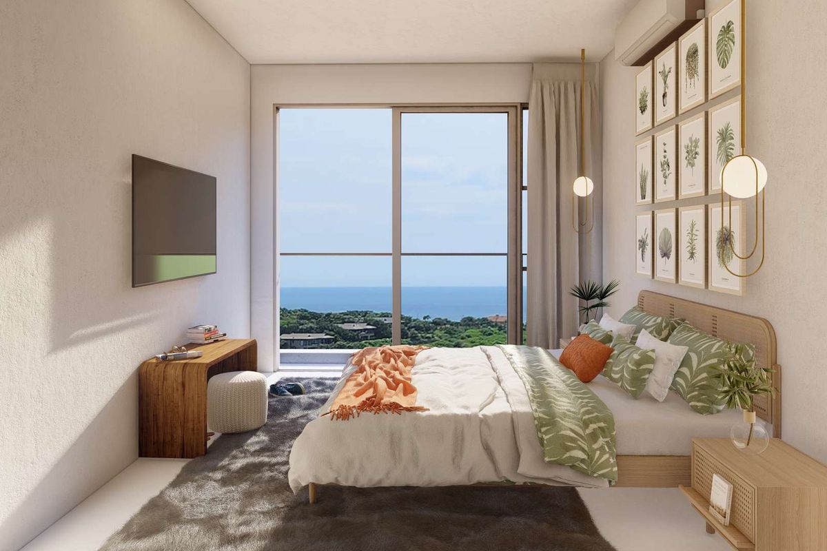 A modern bedroom featuring a large sliding glass door with scenic ocean views and a wall-mounted air conditioning unit.
