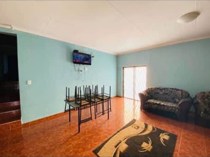 A spacious living area featuring tiled flooring and a sliding glass door providing natural light.