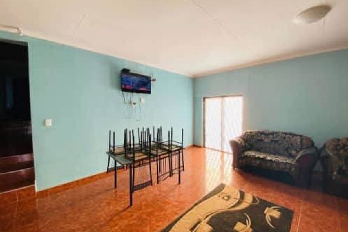 A spacious living area featuring tiled flooring and a sliding glass door providing natural light.