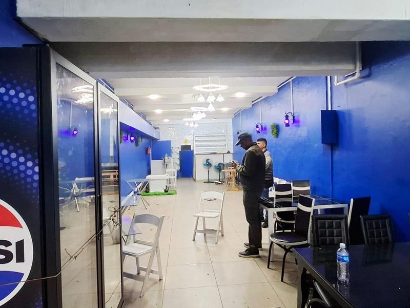 Open plan commercial space featuring tiled flooring and modern ceiling lighting, suitable for a restaurant or retail setup.