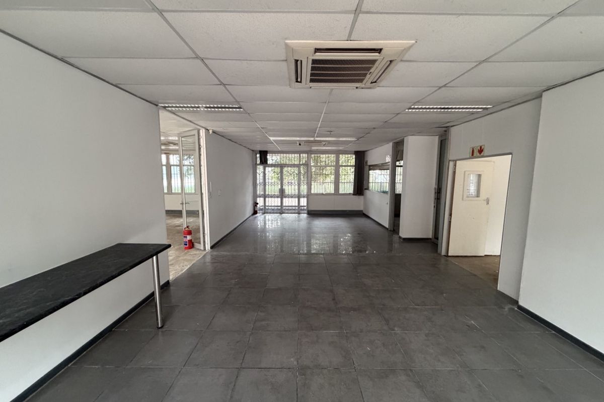 Spacious open-plan office area featuring tiled flooring, suspended ceilings with integrated air conditioning, and secure access points.