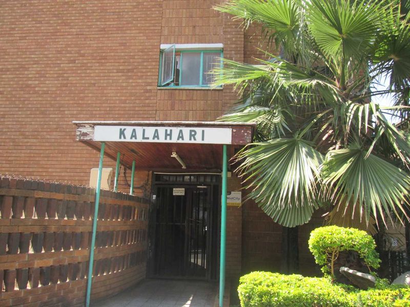 Front entrance of the Kalahari apartment building featuring a brick facade, security gate, and a covered entrance canopy.