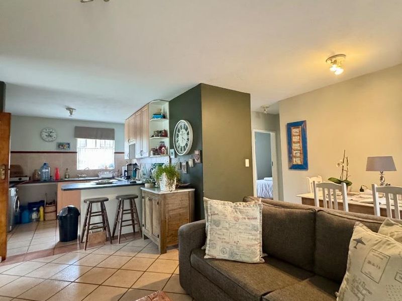 Open plan living and kitchen area featuring tiled flooring, functional cabinetry, and integrated dining space, offering a practical layout for daily living.