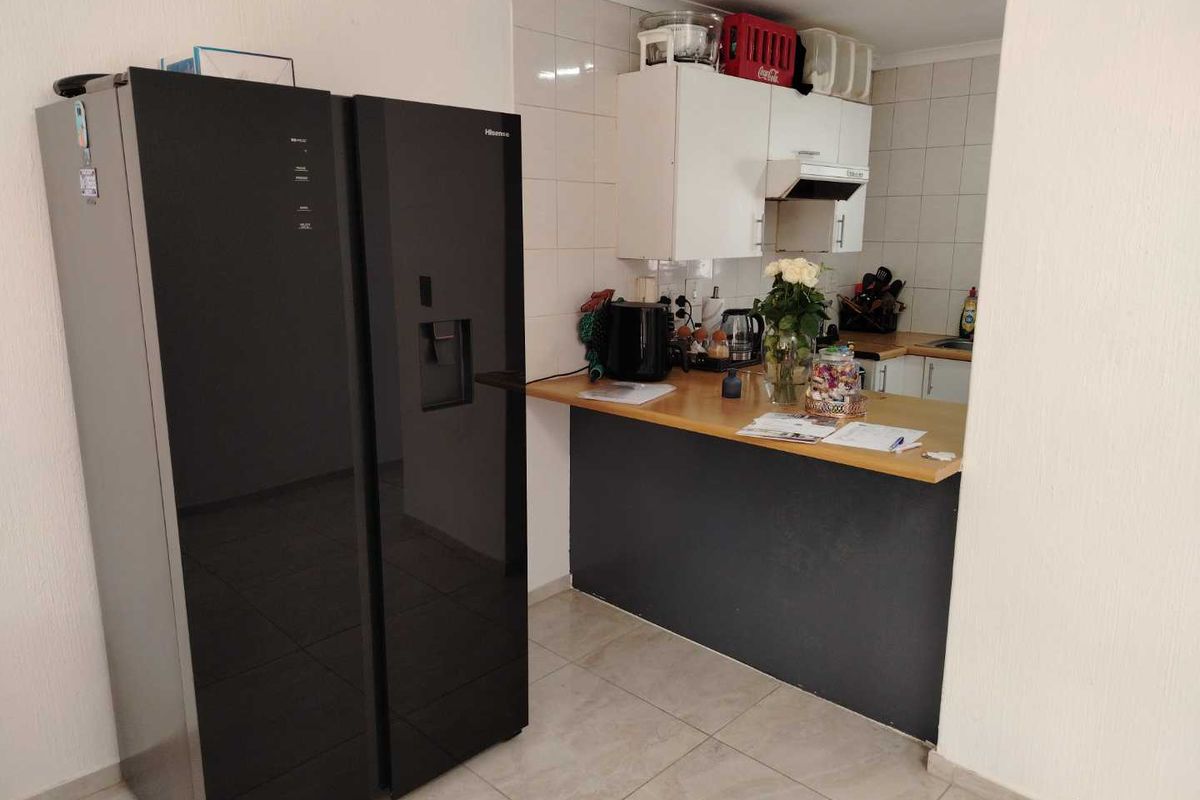 A functional kitchen area featuring built-in cabinetry, a tiled backsplash, and a breakfast counter, providing a practical space for meal preparation.