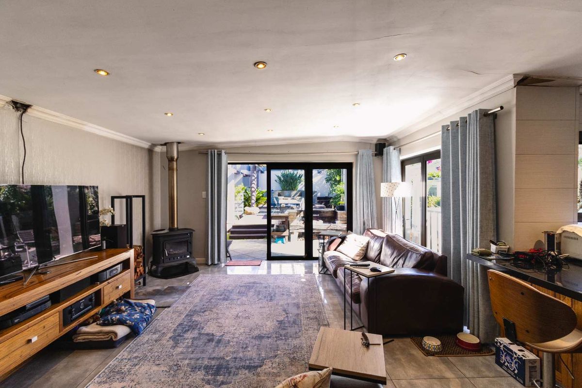 Spacious living area featuring a built-in wood-burning fireplace, tiled flooring, and large sliding glass doors providing seamless access to the outdoor patio.