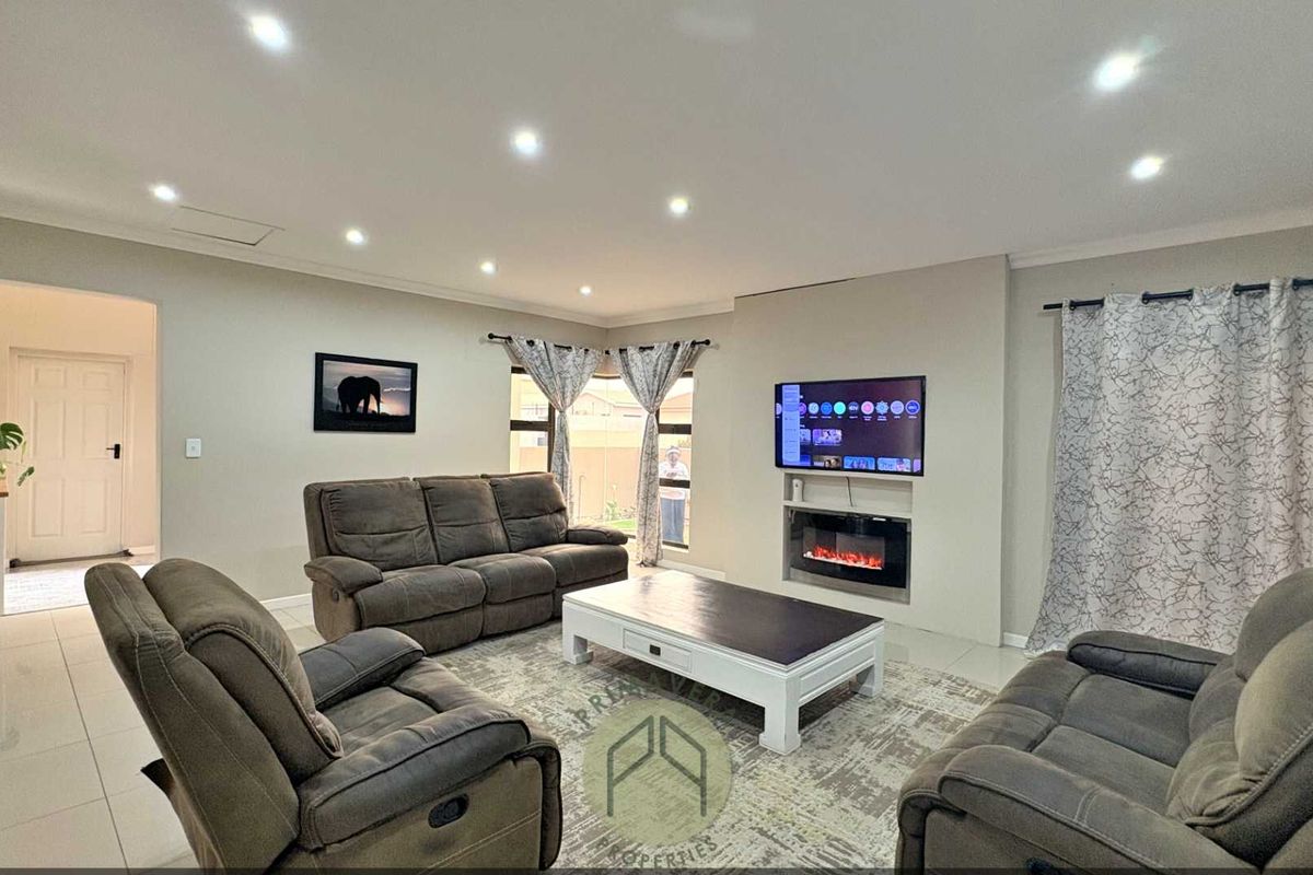 Spacious living room featuring tiled flooring, recessed downlighting, and a modern built-in electric fireplace with a wall-mounted television.