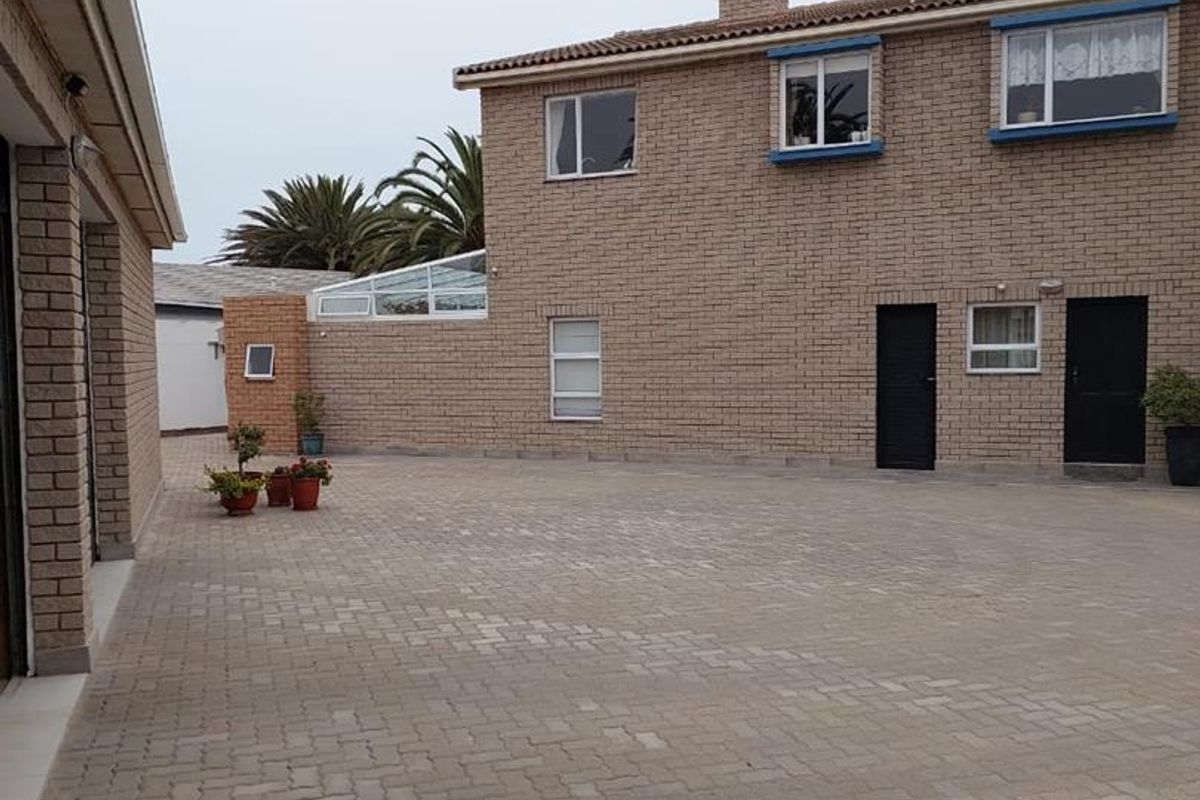 A paved courtyard area featuring a multi-story brick building with multiple entry points and windows, providing a functional outdoor space.