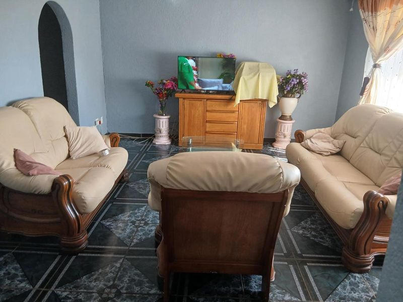 A living room featuring dark patterned floor tiles and an arched architectural detail, providing a functional space for relaxation.