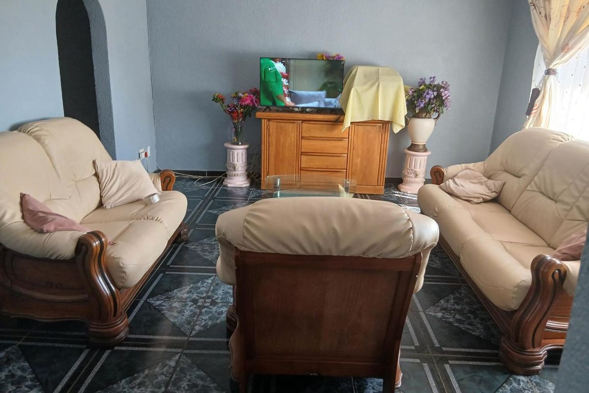 A living room featuring dark patterned floor tiles and an arched architectural detail, providing a functional space for relaxation.