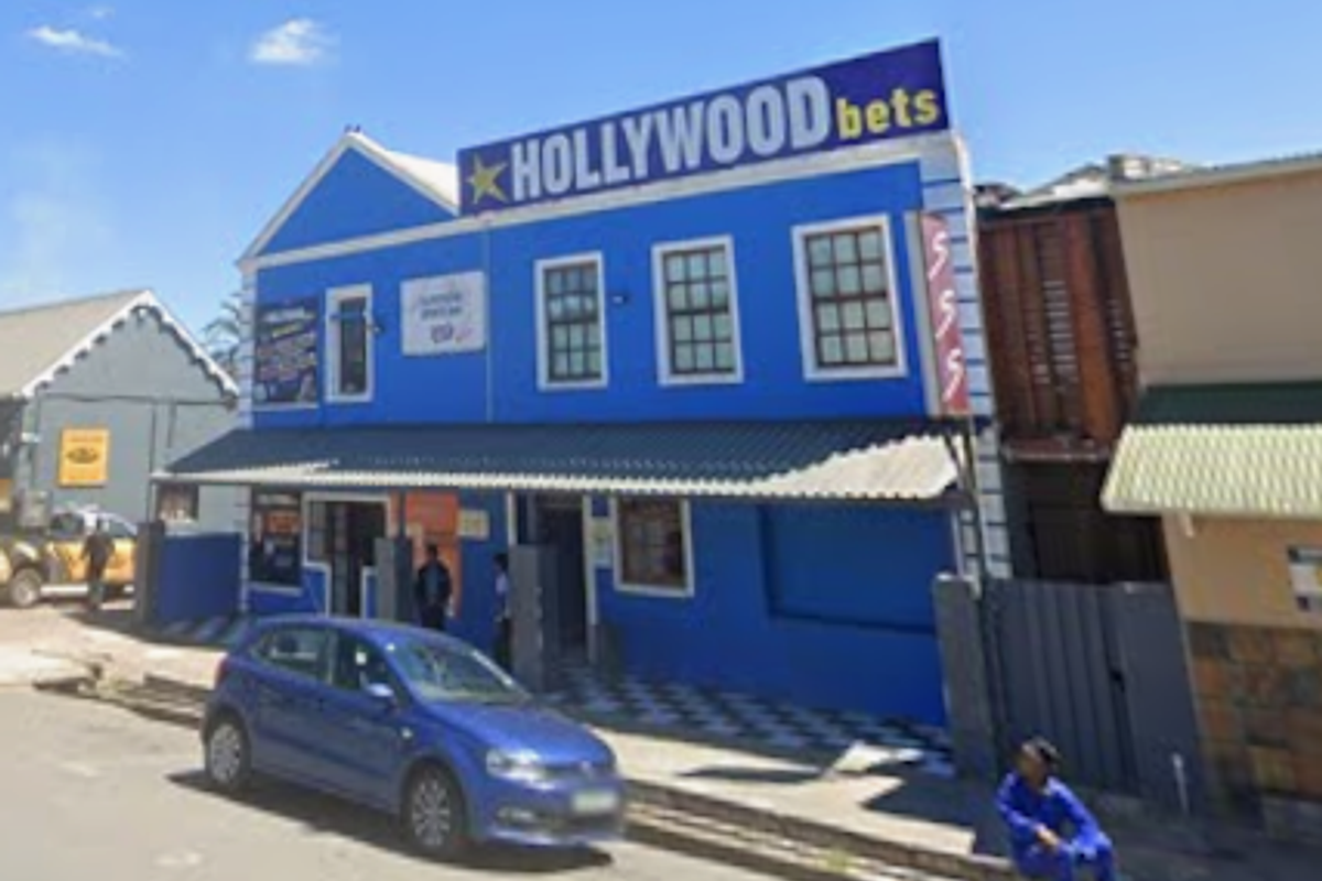 Front facade of a two-story commercial building featuring blue exterior paint, a corrugated metal roof, and a covered entrance area.