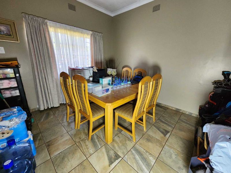 A dining room featuring tiled flooring and neutral wall finishes, providing a functional space for family meals.