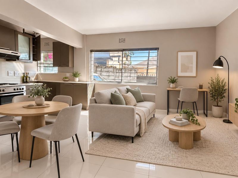 Modern open-plan living area featuring a sleek kitchen with built-in cabinetry, integrated appliances, and bright, tiled flooring throughout the space.