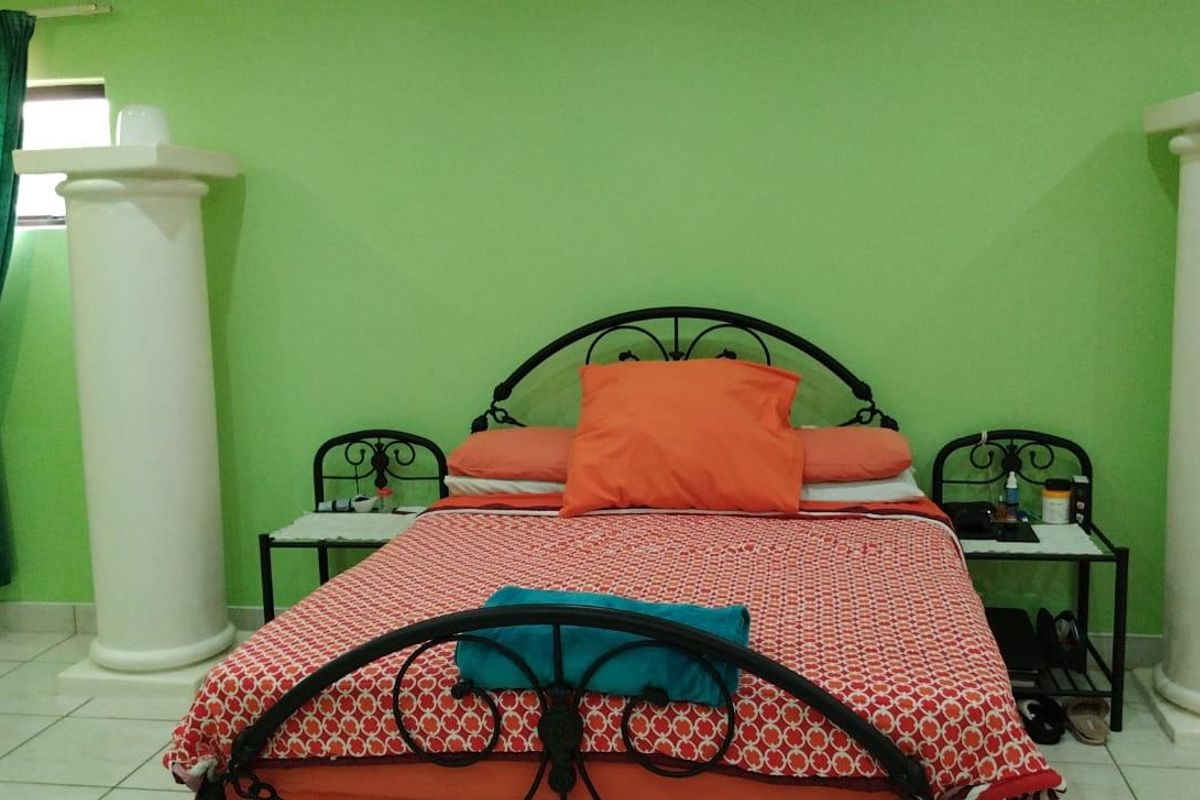 A bedroom featuring tiled flooring and decorative architectural columns flanking the bed area.