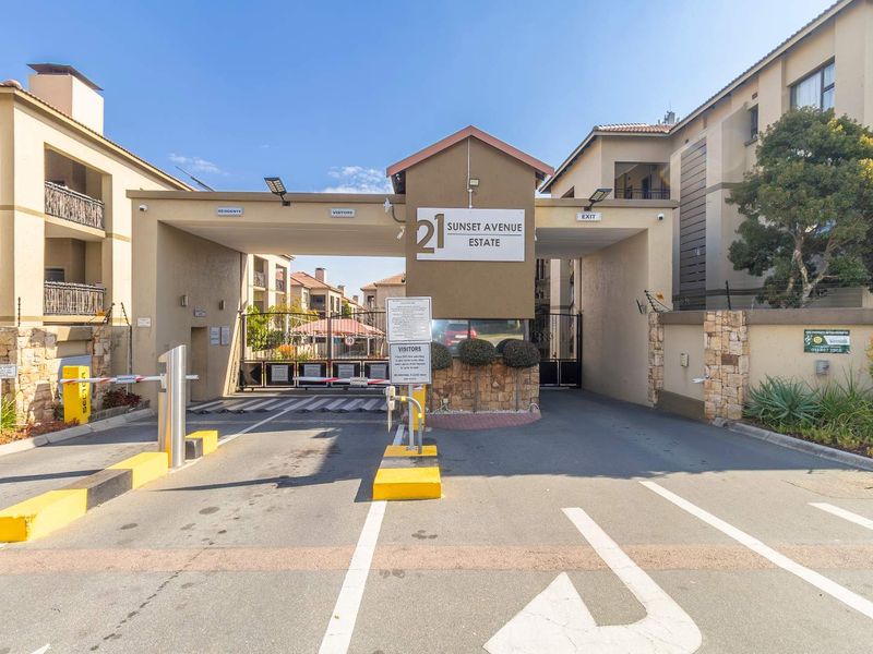 The secure gated entrance to Sunset Avenue Estate, featuring a controlled access boom gate, signage, and perimeter walling.