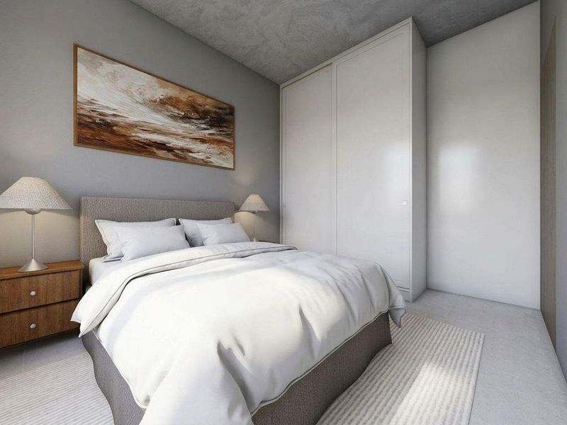 Modern bedroom featuring a sleek built-in wardrobe and a contemporary concrete ceiling finish.