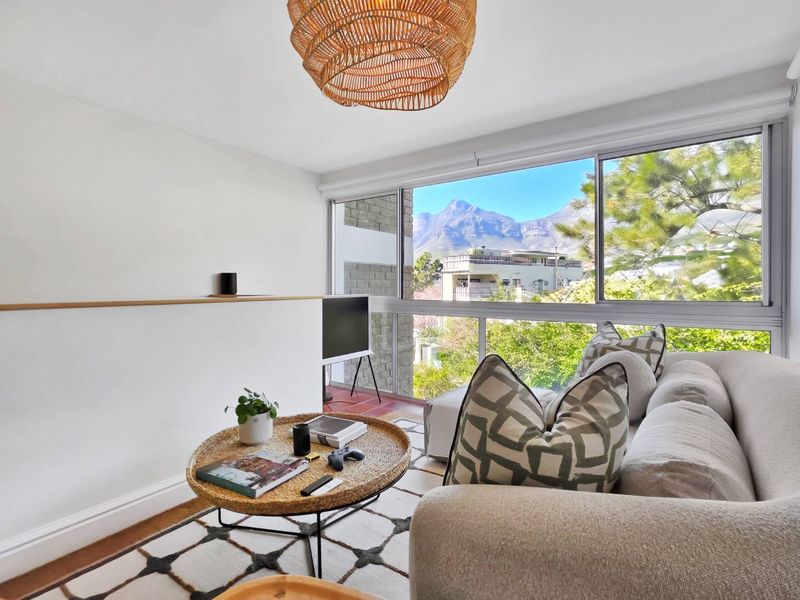 A bright living room featuring large sliding windows that offer scenic mountain views and provide ample natural light.